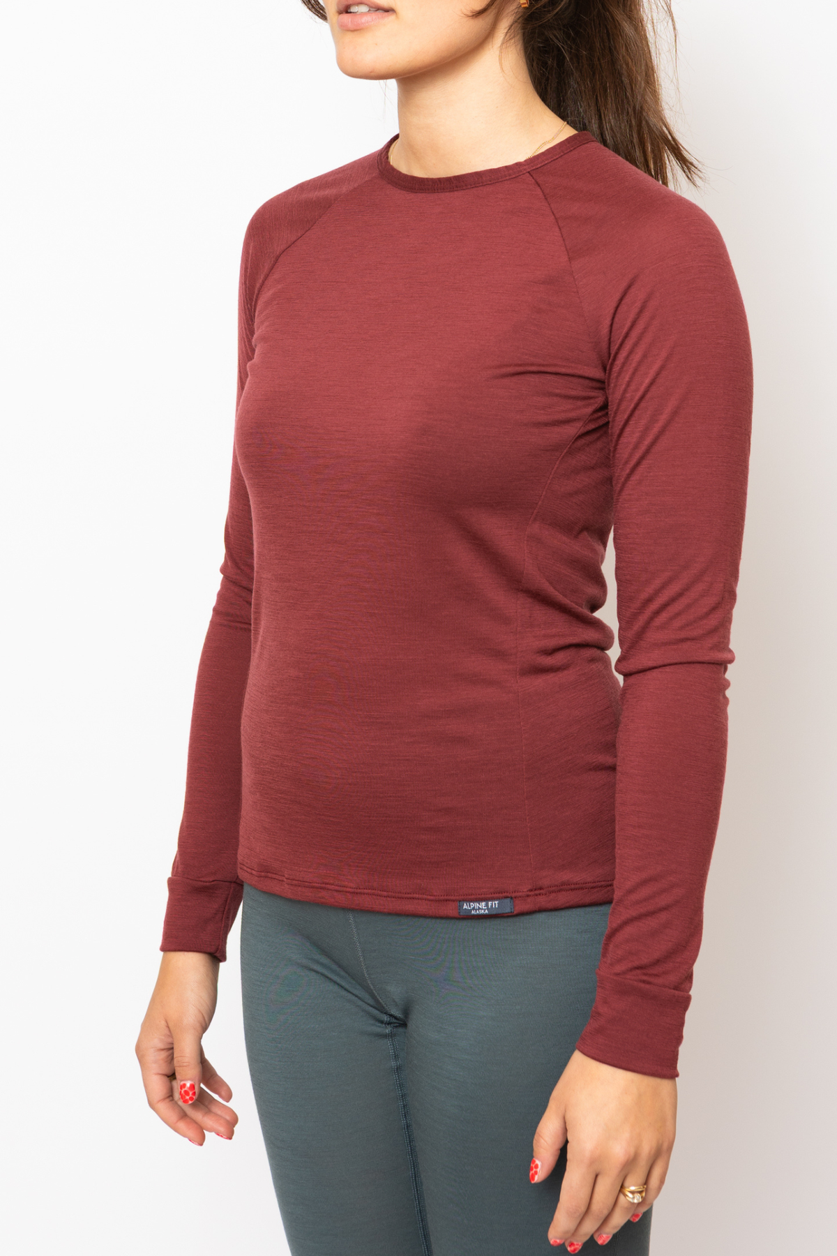 Alpine Fit Every Day Merino Wool Long Sleeve Fall Fireweed, Person wearing a maroon long-sleeve shirt with a visible brand logo on a white background