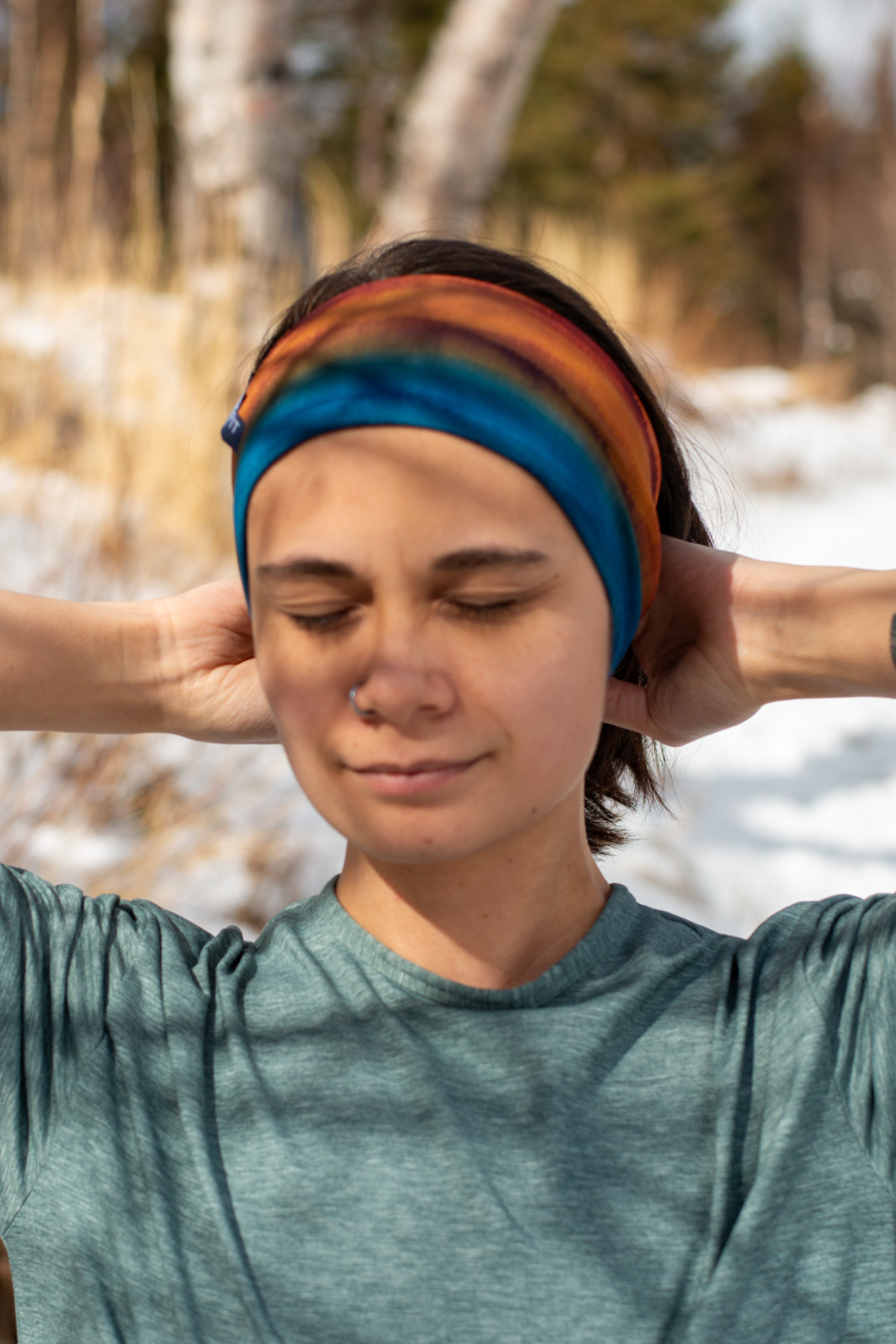 Alpine fit Merino wool lined headband grasslands on woman, close up image, Outdoors blurry background