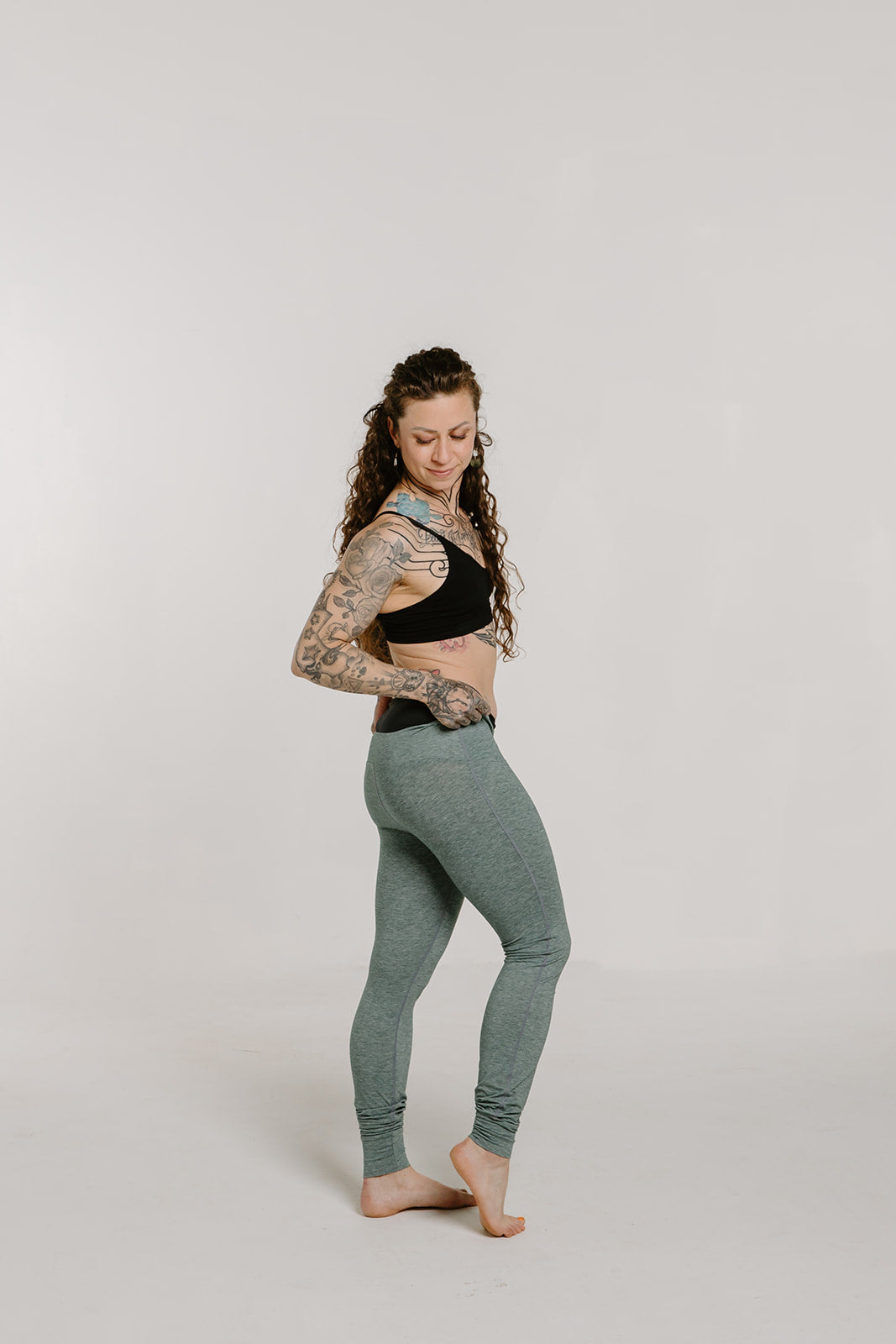 Alpine Fit Athletic Hipster Black on woman, full right side view layered using backcountry base layer bottoms, off-white background