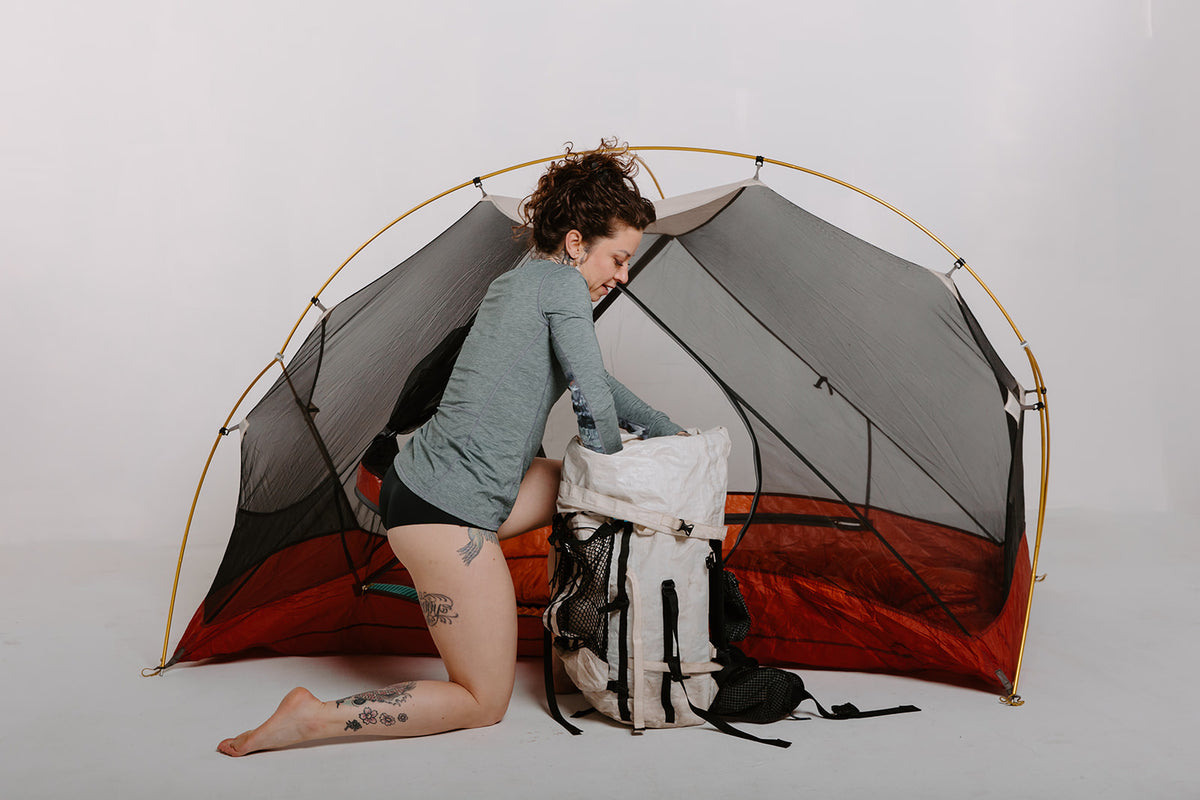 Alpine Fit Athletic Hipster Black on a woman, full right side view, camping, off-white background
