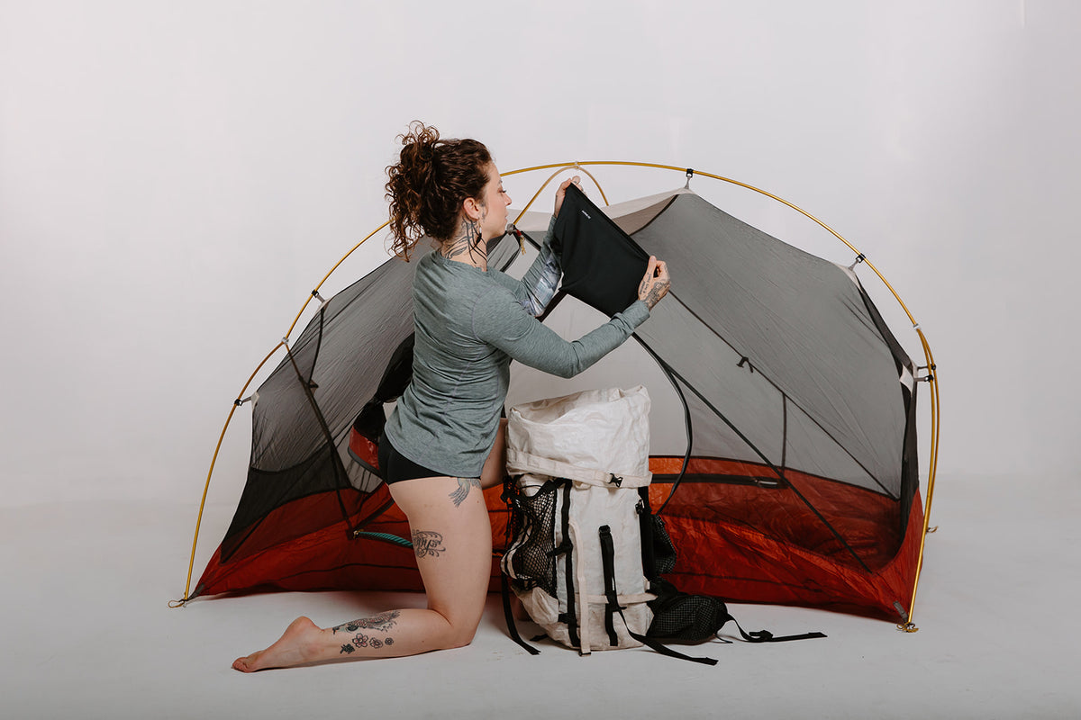 Alpine Fit Athletic Hipster Black on a woman, full right side view, camping, off-white background
