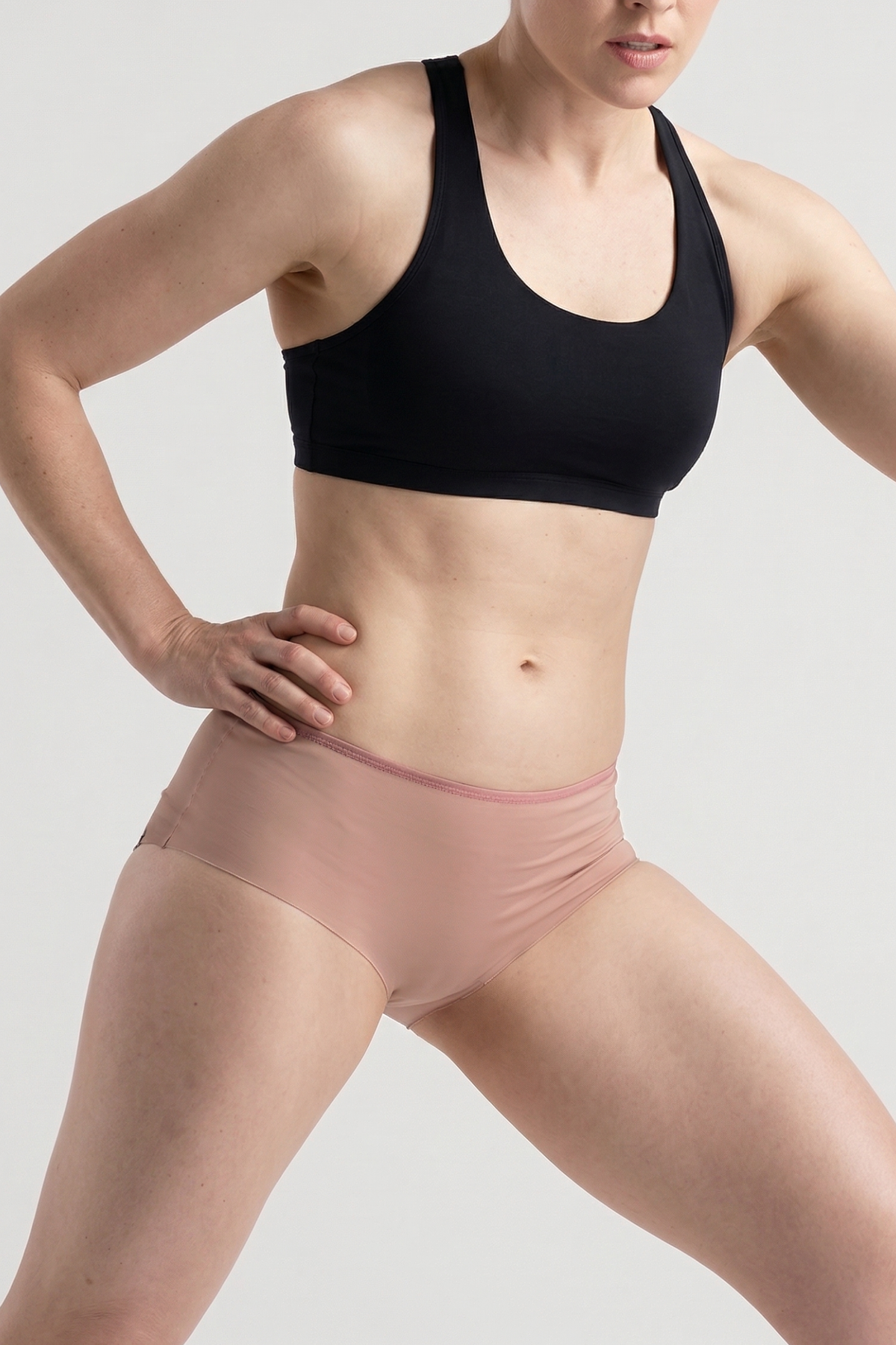 Alpine Fit Athletic Hipster Black, Person wearing a black sports bra and pink underwear on a plain background