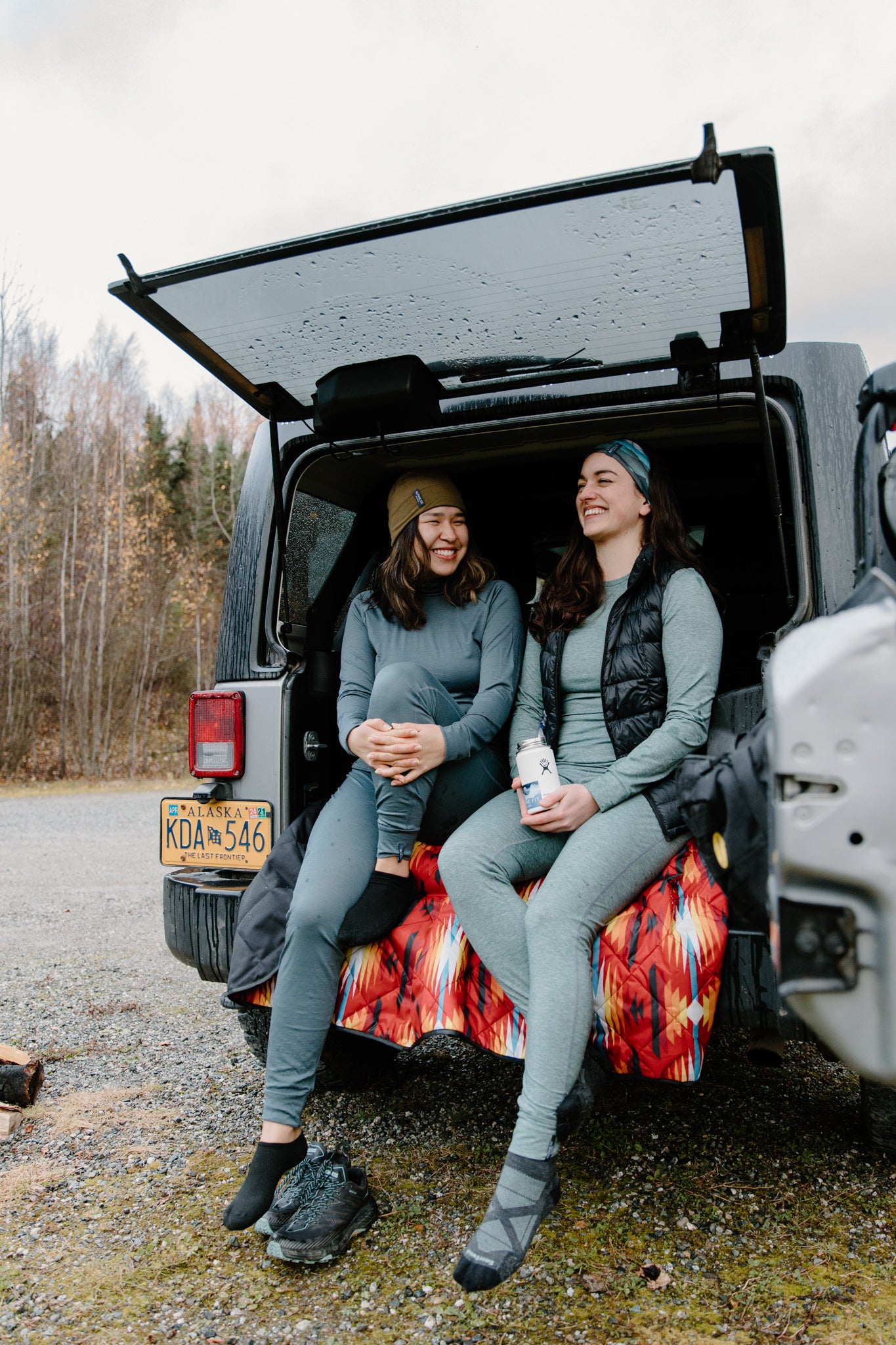 alpine fit base layers on models camping outside