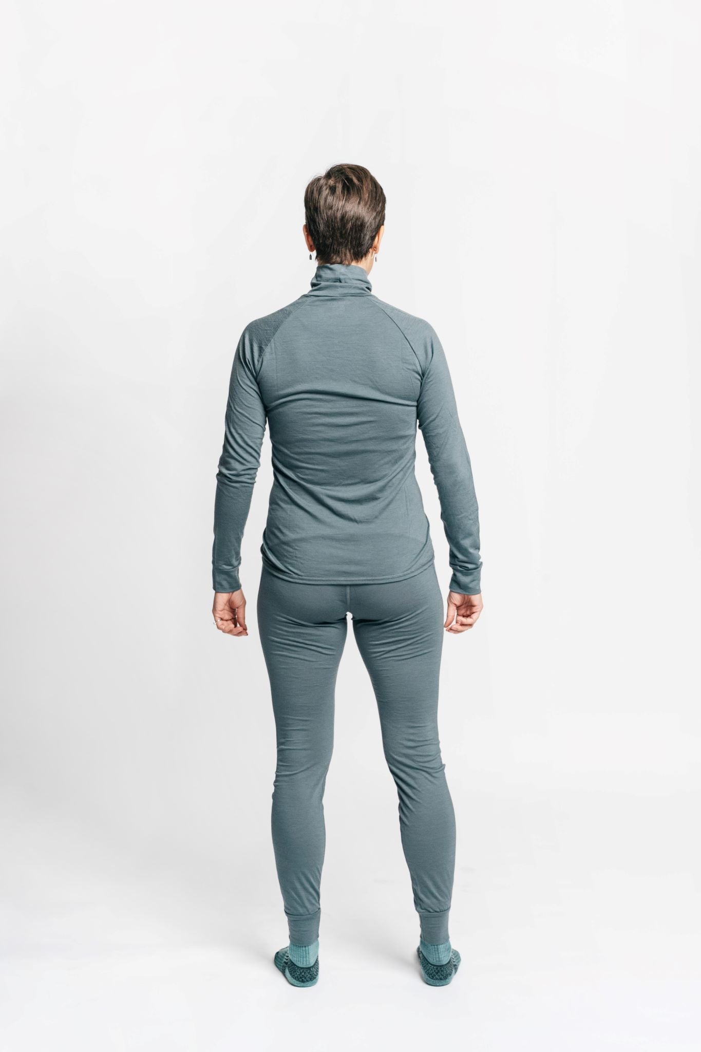 alpine fit merino wool base layer top and bottom on model viewed from the back