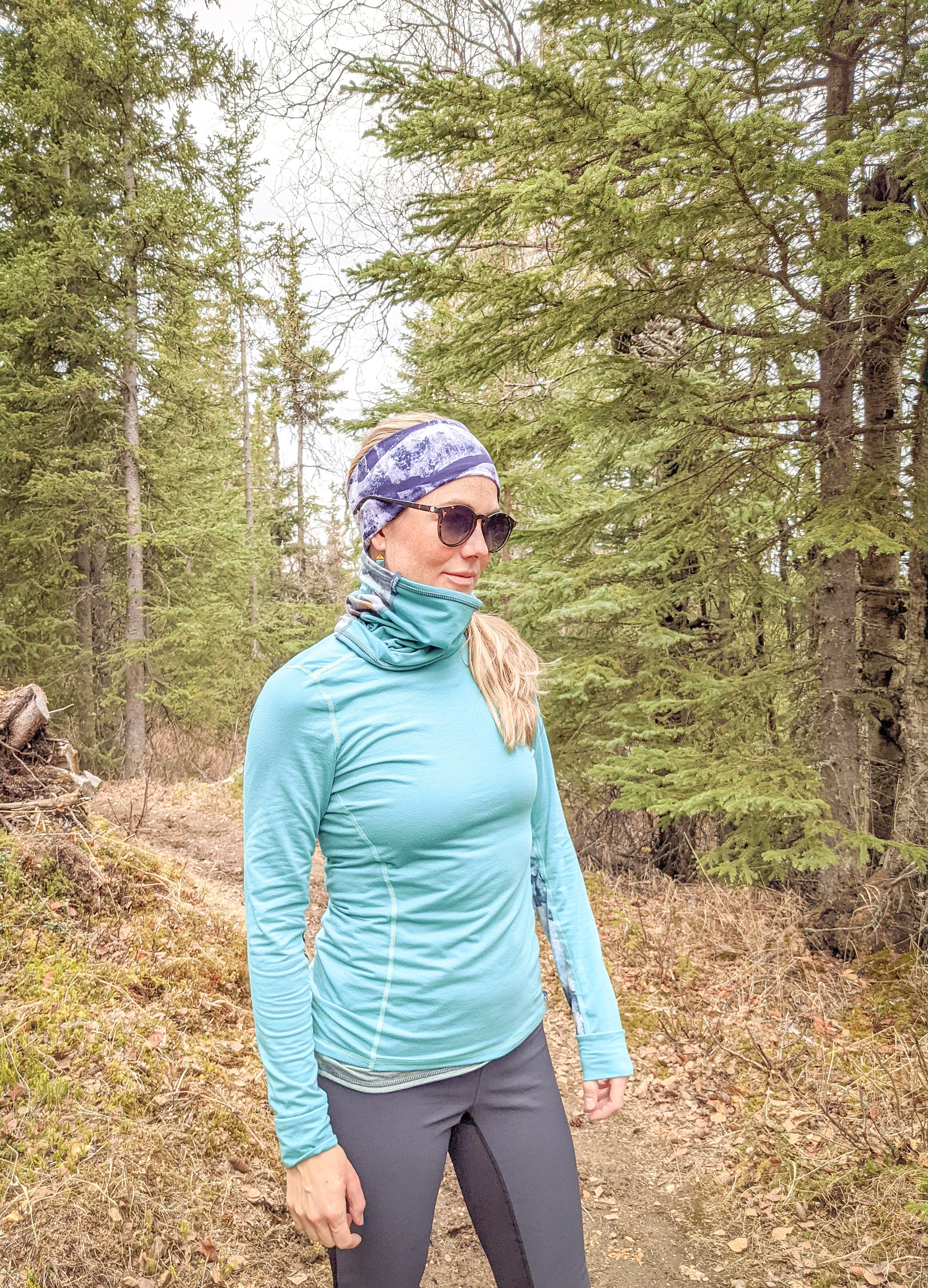 alpine fit neck gaiter on model outside in forest