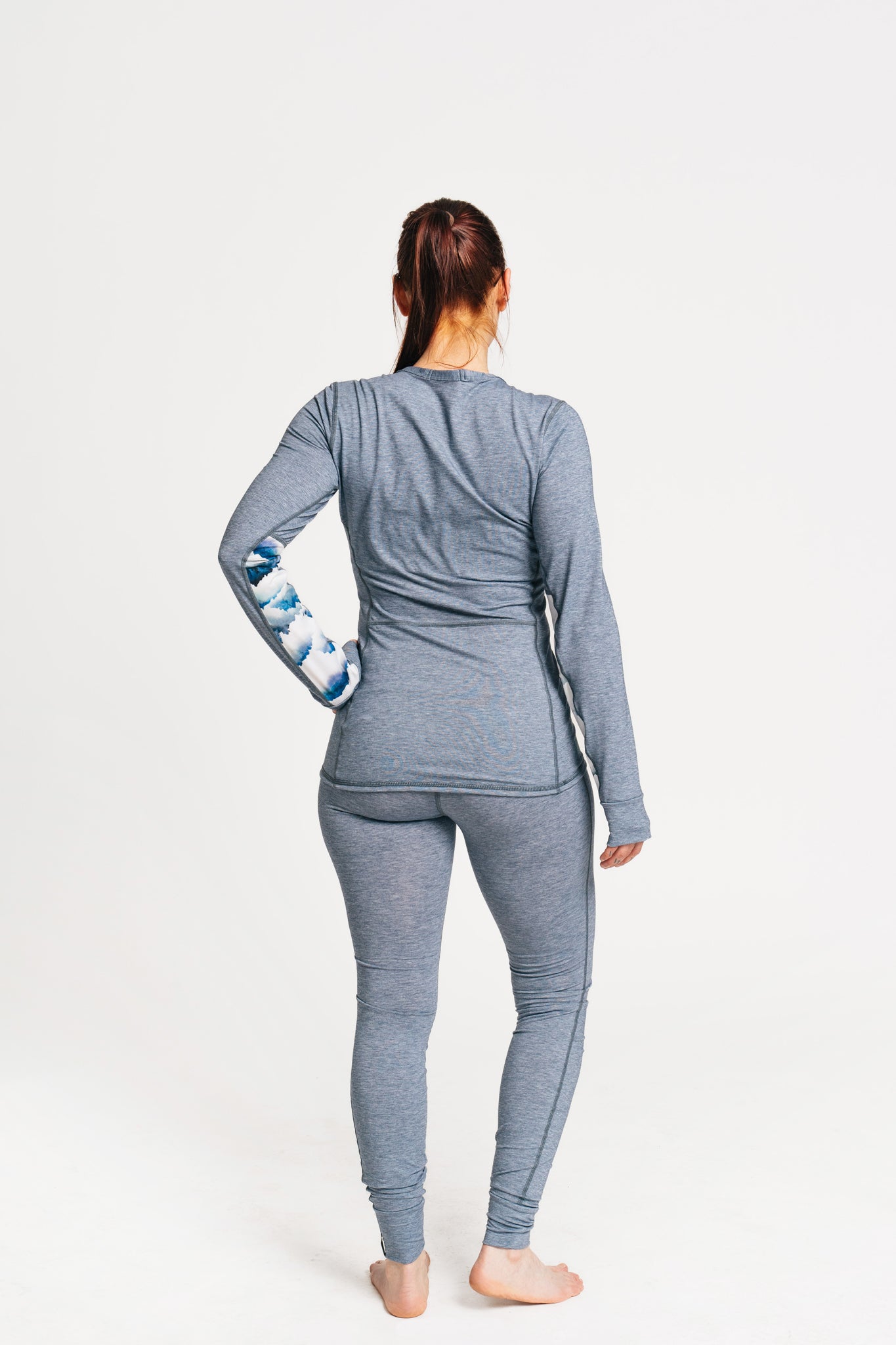 alpine fit blue base layer top and bottom with model viewed from the back