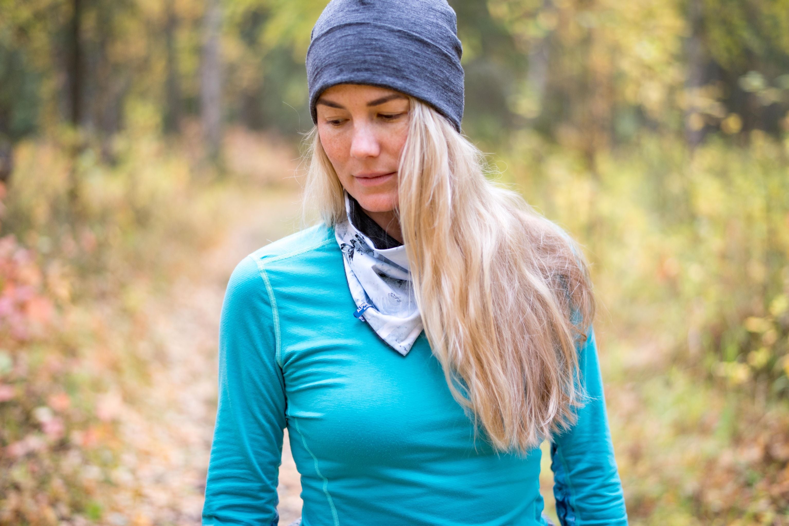 alpine fit neck gaiter on model outside with hat and base layer top