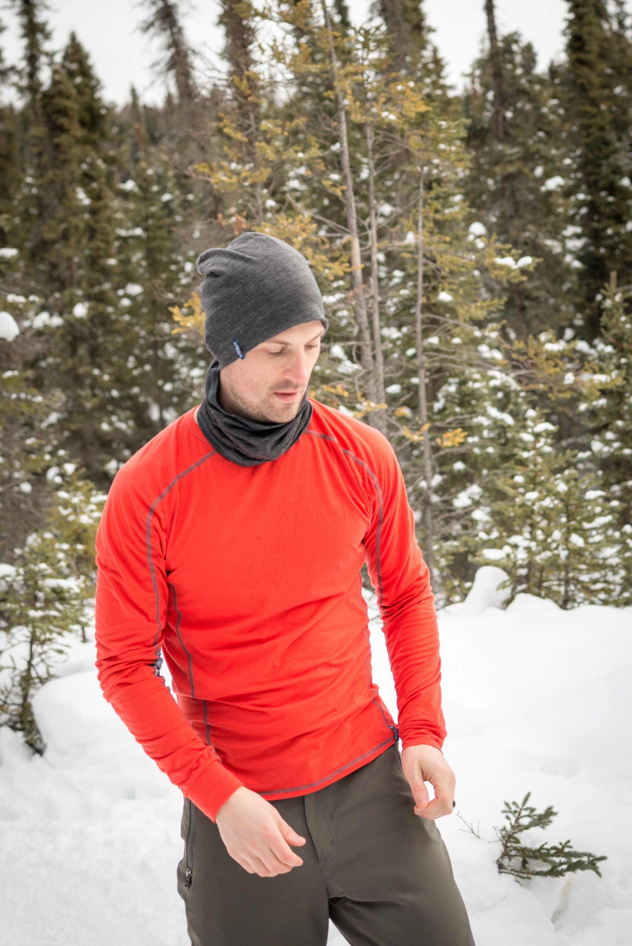 alpine fit merino wool neck gaiter on male model outside with merino wool hat and base layer top